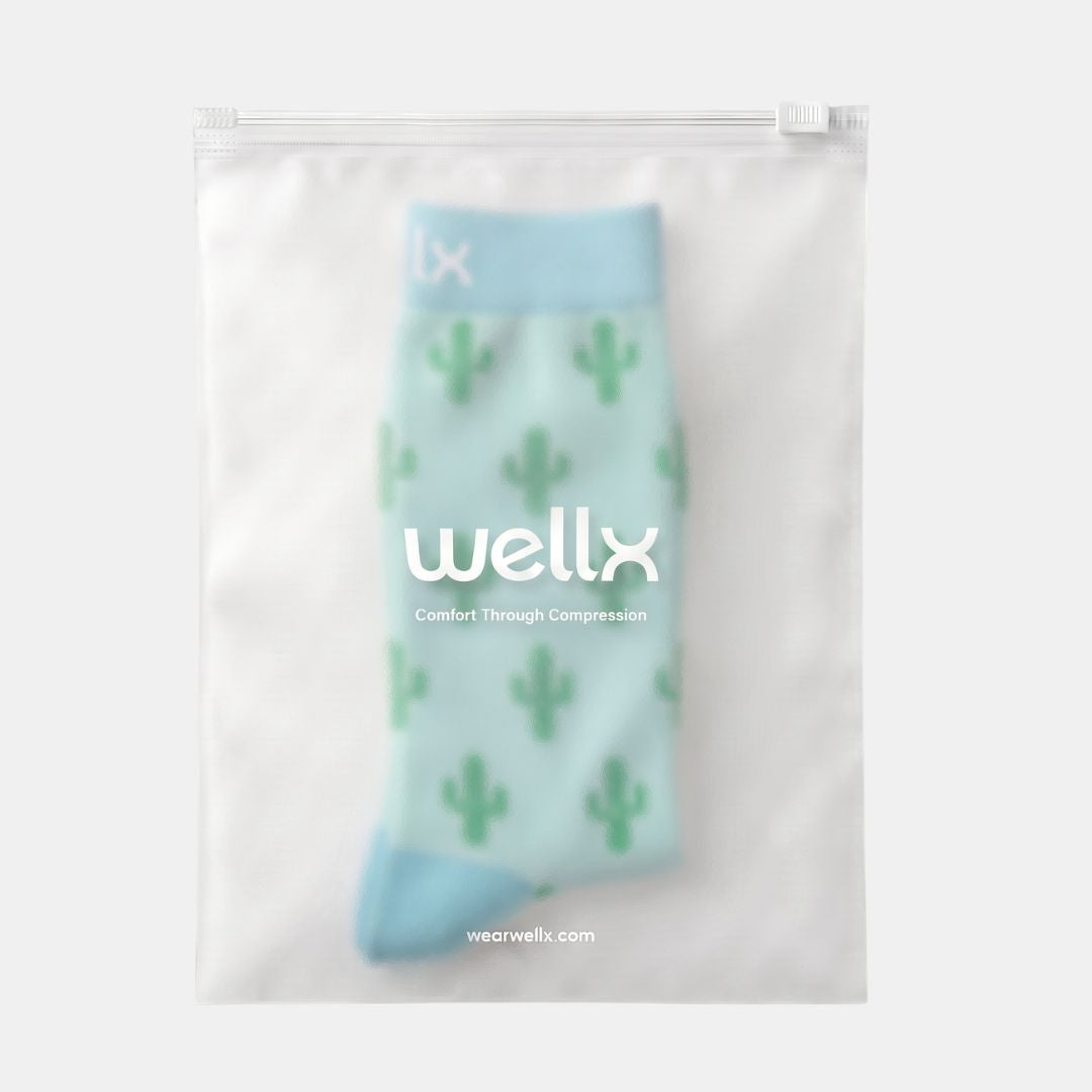 Cactus Green Compression Socks For Men A single light blue cactus-print sock inside a clear resealable pouch with the brand name 'wellx' printed on the front, set against a light gray background.