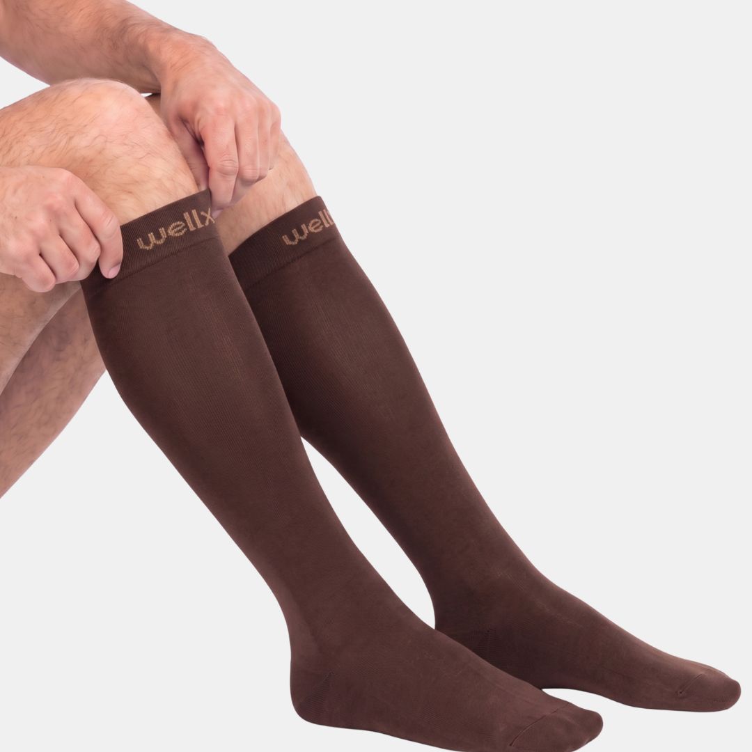 Espresso Compression Socks For Men, Espresso brown knee-high compression socks for men, shown being pulled up over the calf, side view on white background