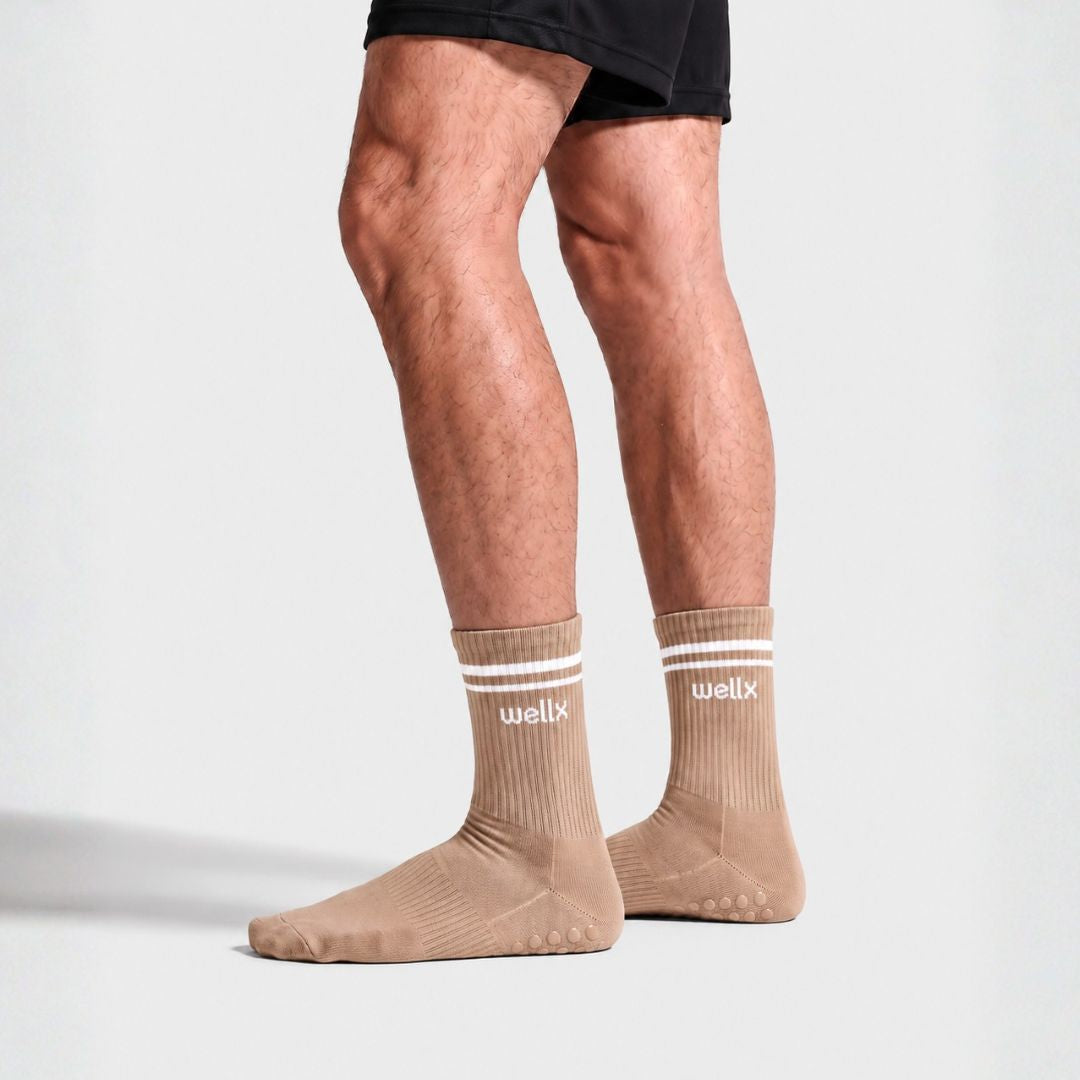 Man standing in Gravel Balance Grip Socks For Men with black shorts, side view against a light background
