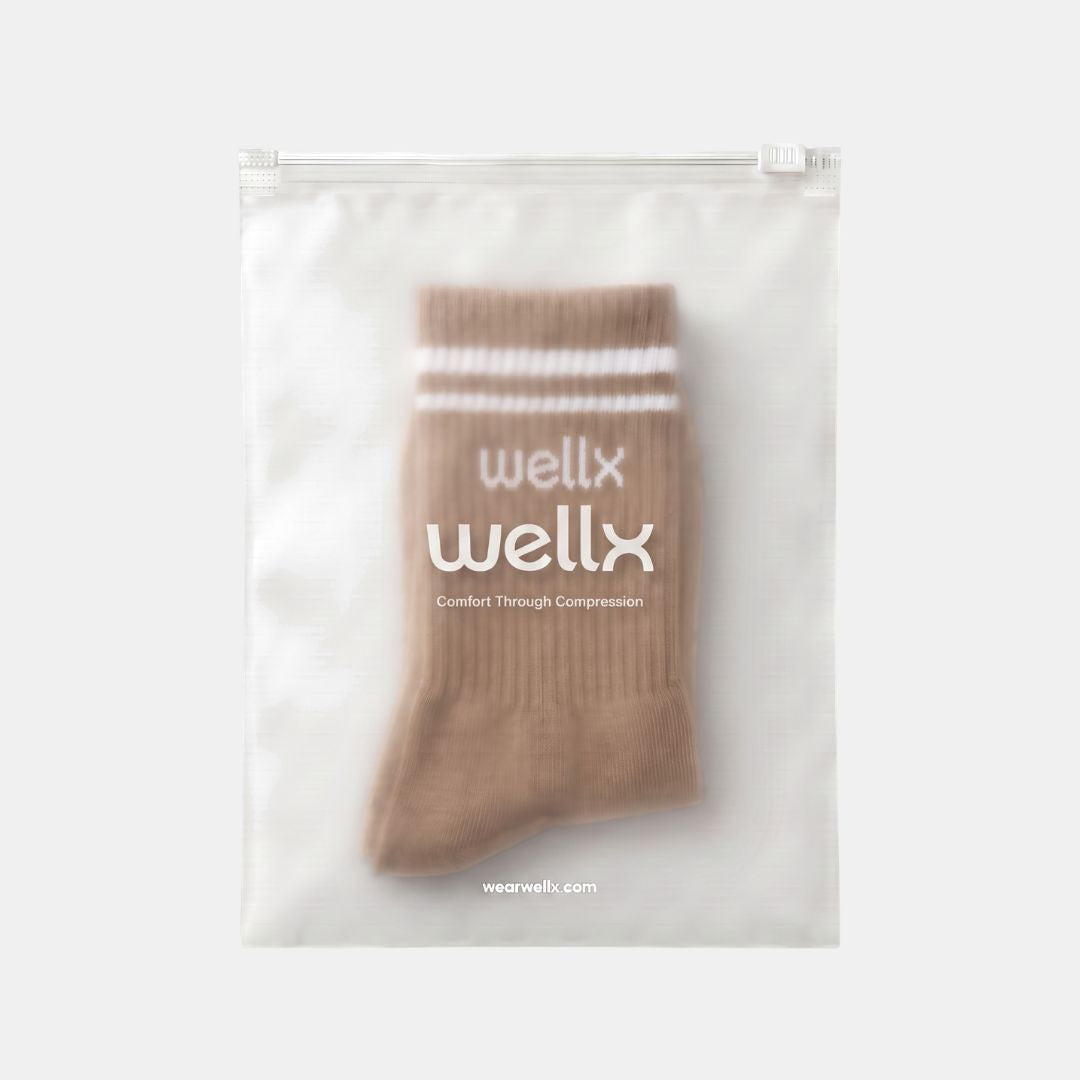 Gravel Balance Grip Socks For Men packaging, taupe sock with white stripe cuff visible through a frosted Wellx zip pouch on a light grey background