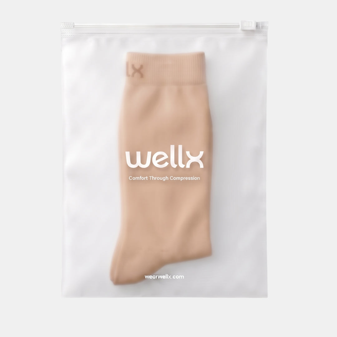 Gravel Toeless Compression Socks For women A beige compression sock displayed inside a clear, white drawstring pouch with the brand name 'wellx' printed on the front.