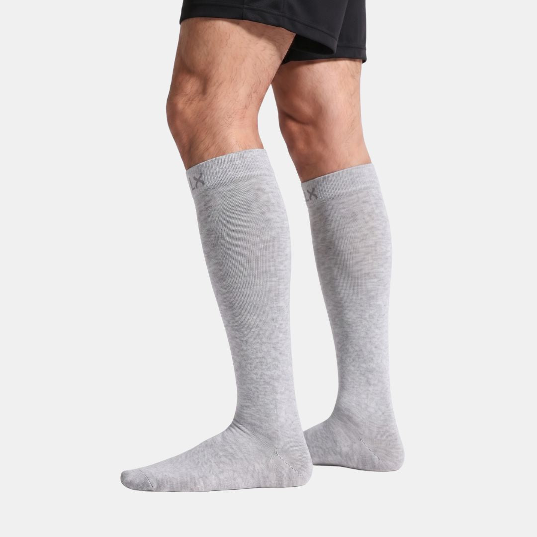 Silver Grey Compression Socks For Men, Light grey knee-high socks worn by a man in black shorts, side view