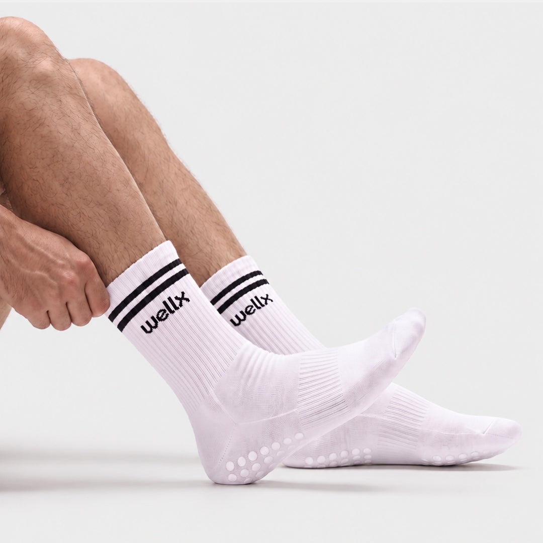 White Balance Grip Socks For Men with non-slip silicone grip sole, ribbed crew knit and black double-stripe cuff, shown from the side