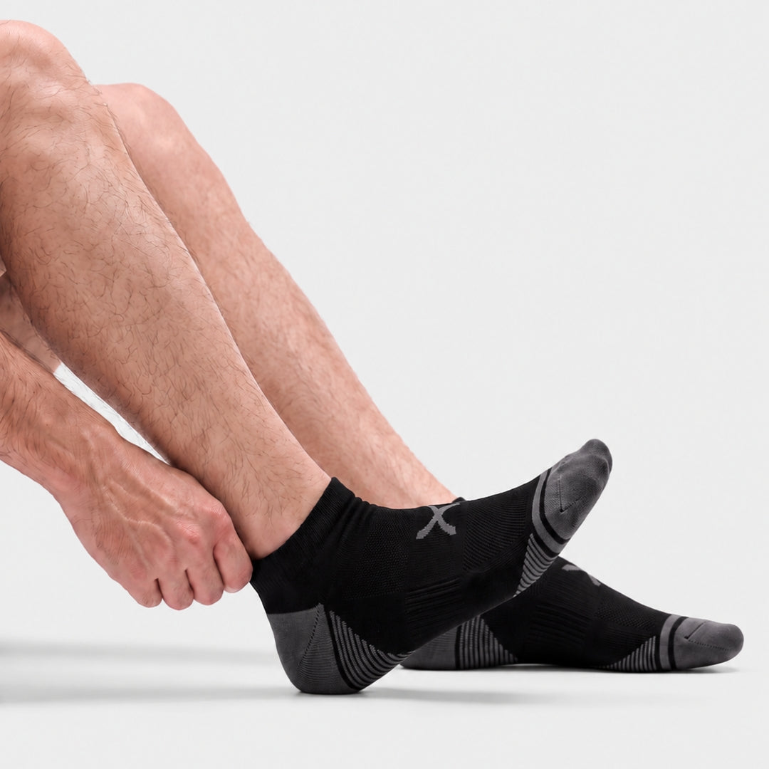 Black Power Stride Ankle Socks For Men, side view with hand adjusting the cuff