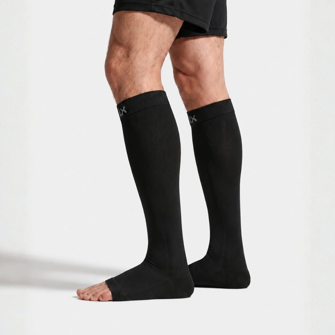 Black Toeless Compression Socks For Men Black compression socks worn on a person's legs, shown from the mid-thigh down against a clean white studio background.