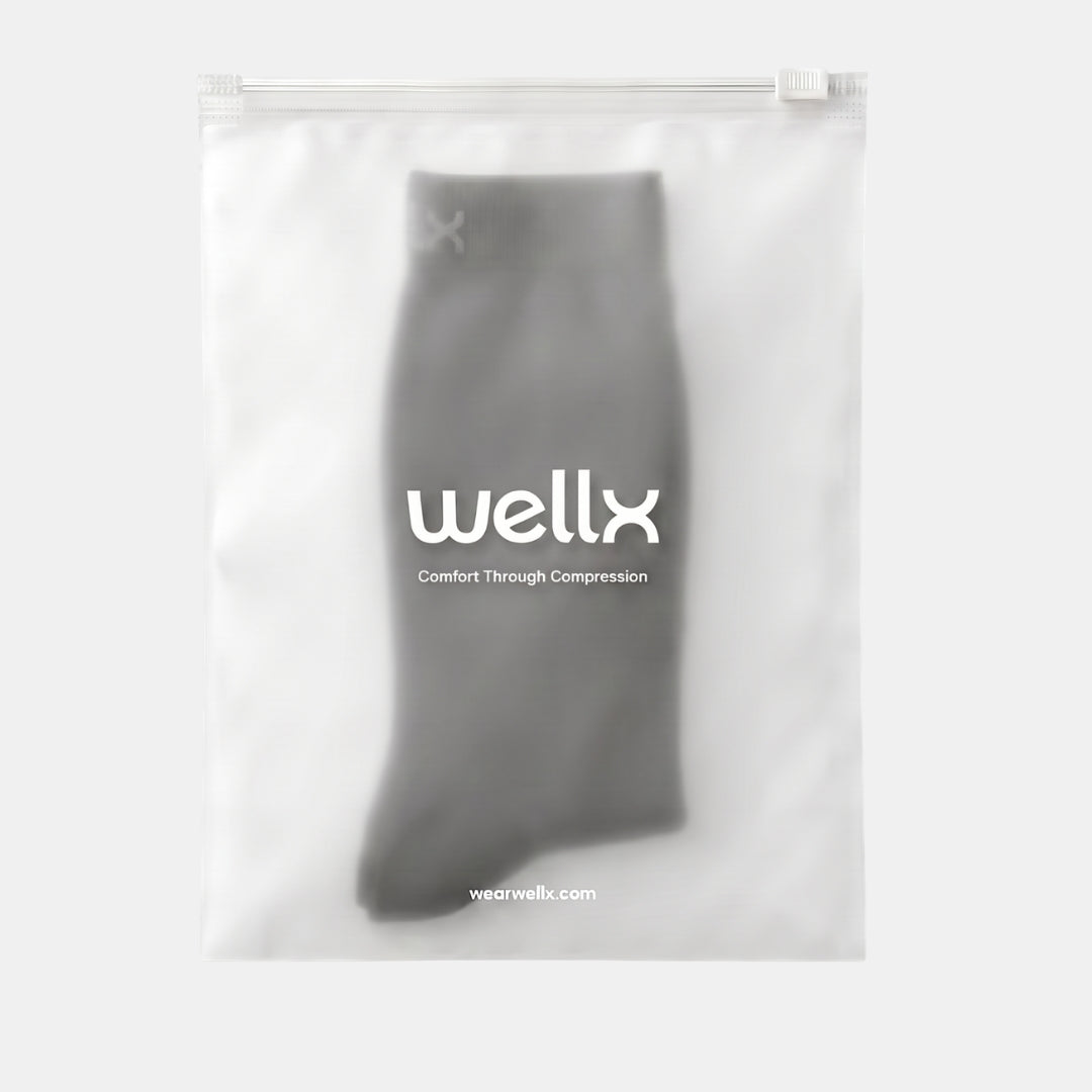 Black Toeless Compression Socks For Men  A gray compression sock inside a clear, resealable plastic bag with the brand name 'wellx' printed in white on the front, set against a light gray background.