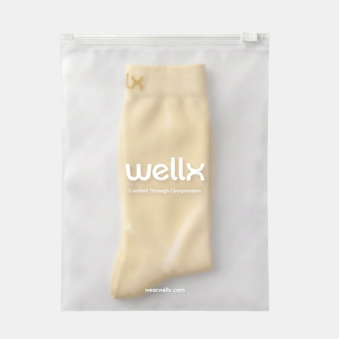 Candlelight Yellow Compression Socks For Women packaging, cream sock visible through a frosted Wellx zip pouch on a light grey background