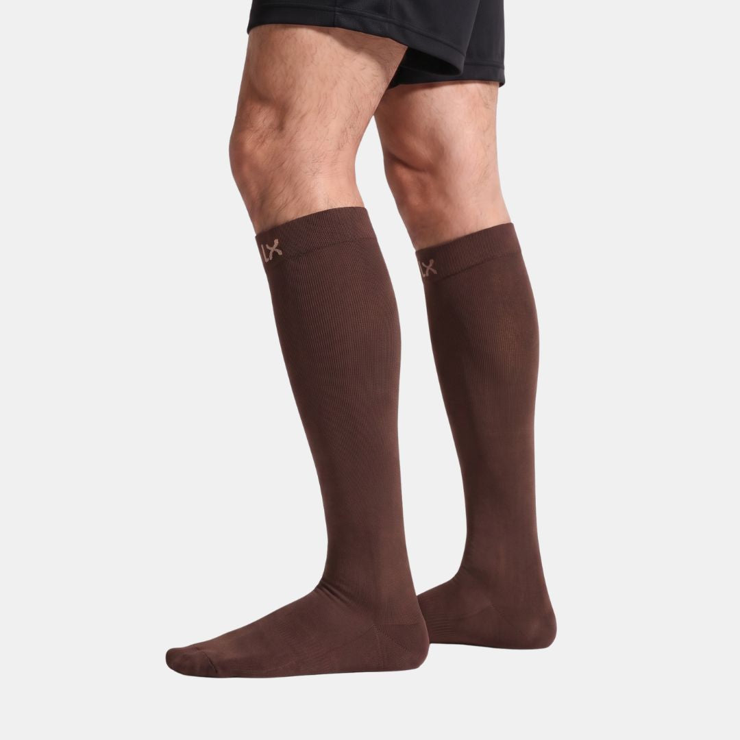 Espresso Compression Socks For Men, A pair of dark brown knee-high compression socks worn on a model's legs, shown against a plain light gray background.